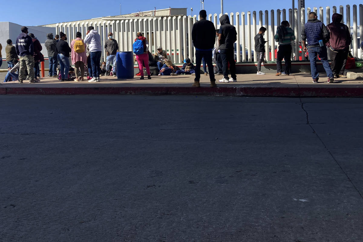 Migrants waiting to cross into the United States wait for news at the border crossing Wednesday ...