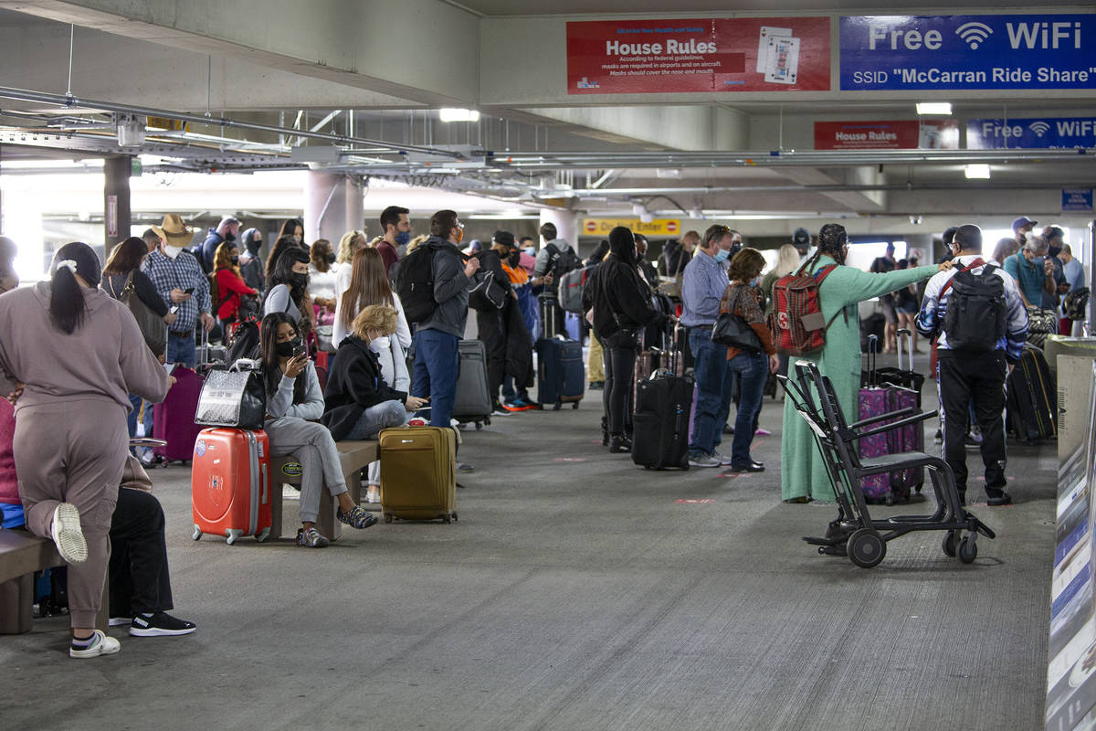 A crowd of people waits for ride shares at McCarran International Airport on Friday, March 19, ...