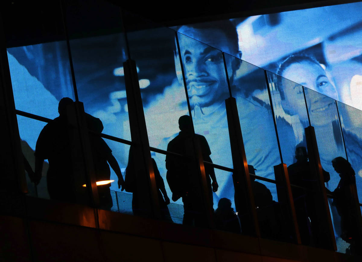 People cross a pedestrian bridge on the Las Vegas Strip, Friday, March 19, 2021. (Chitose Suzuk ...