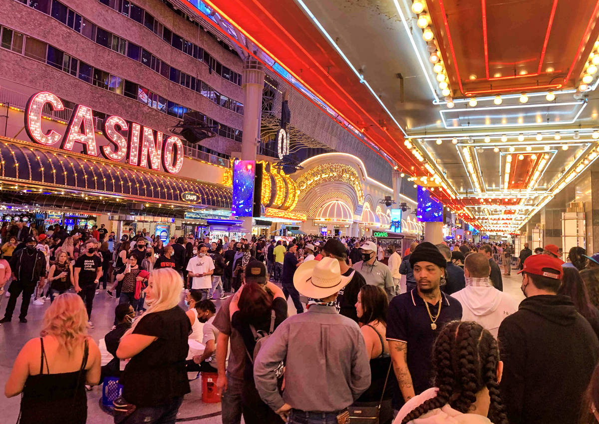 People walk along Fremont Street Experience in Las Vegas, Friday, March 19, 2021. (David Guzman ...