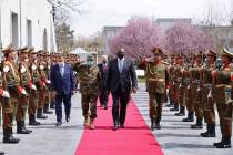 U.S. Defense Secretary Lloyd Austin, center, walks on the red carpet with Acting Afghan Ministe ...