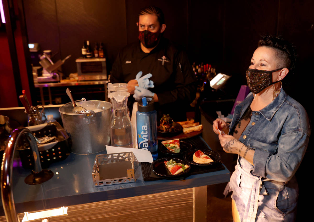 Owner Randi Garrett and Allan Garay prepare to deliver food orders on reopening night at Cork a ...