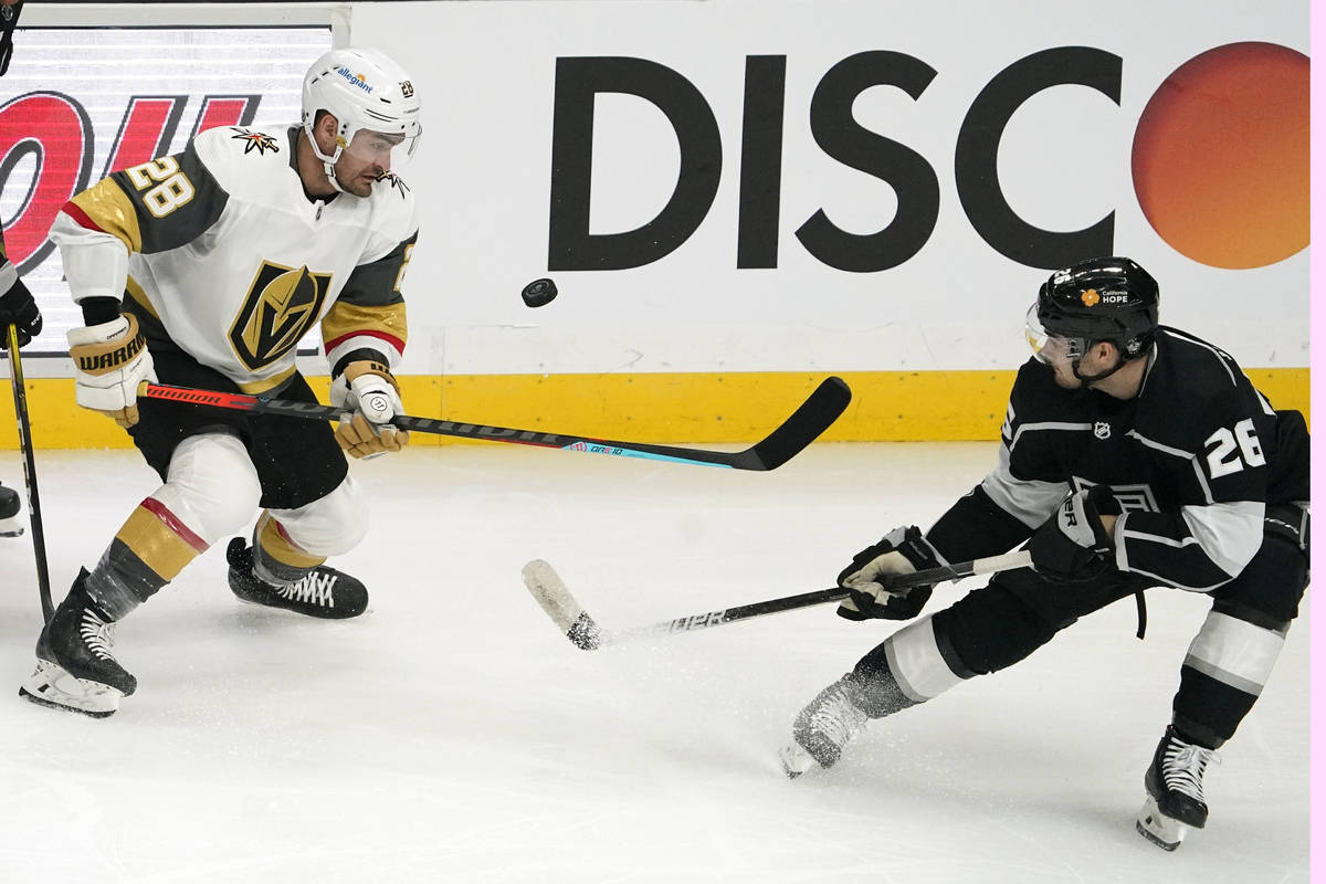 Vegas Golden Knights left wing William Carrier, left, tries to knock the puck out of the air wh ...
