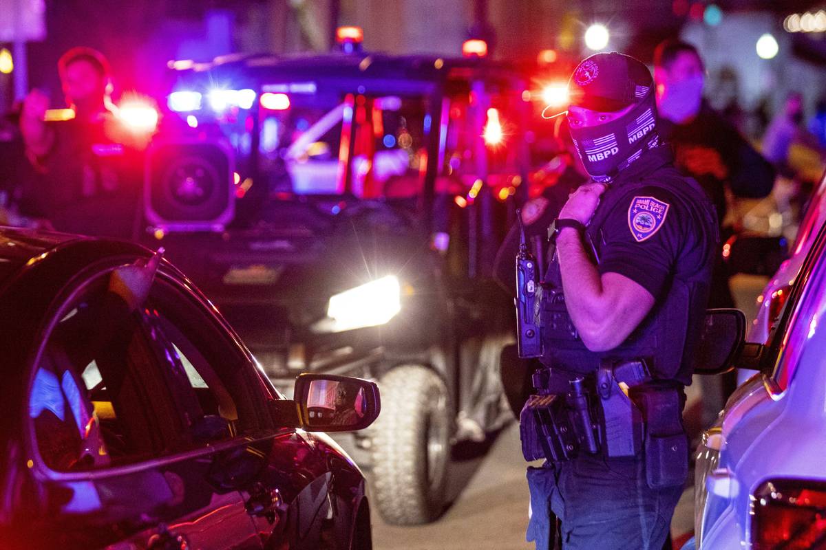 Miami Beach Police arrive on the scene to disperse a crowd that formed near Seventh Street and ...