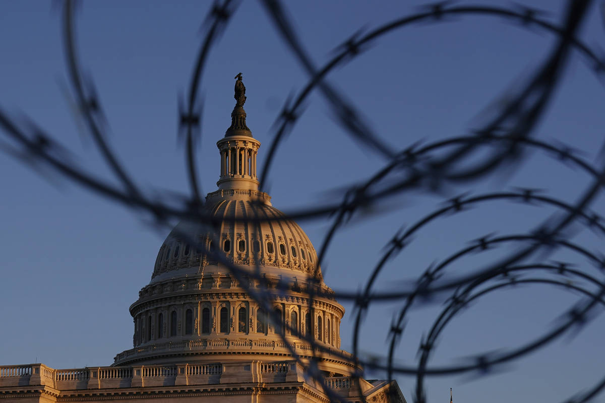 The Capitol is seen through razor wire at sunrise in Washington, Friday, March 5, 2021. (AP Pho ...