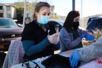 Physician assistant student Erica Moran, left, preps COVID-19 vaccines next to fellow physician ...