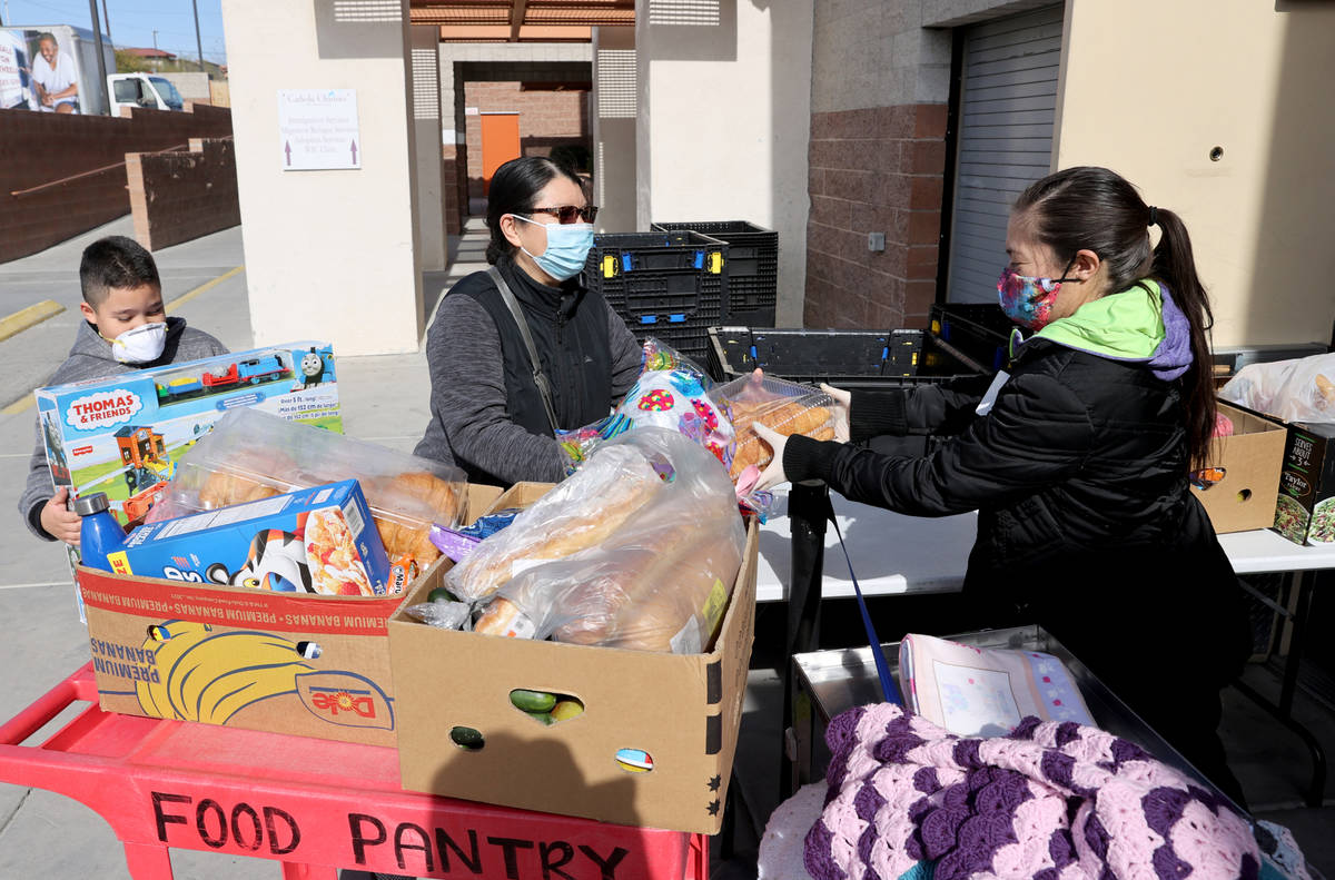 Roxy Hernandez, right, loads food for Jeremy Galindo, 10, and his mother Delmy Galindo at the H ...