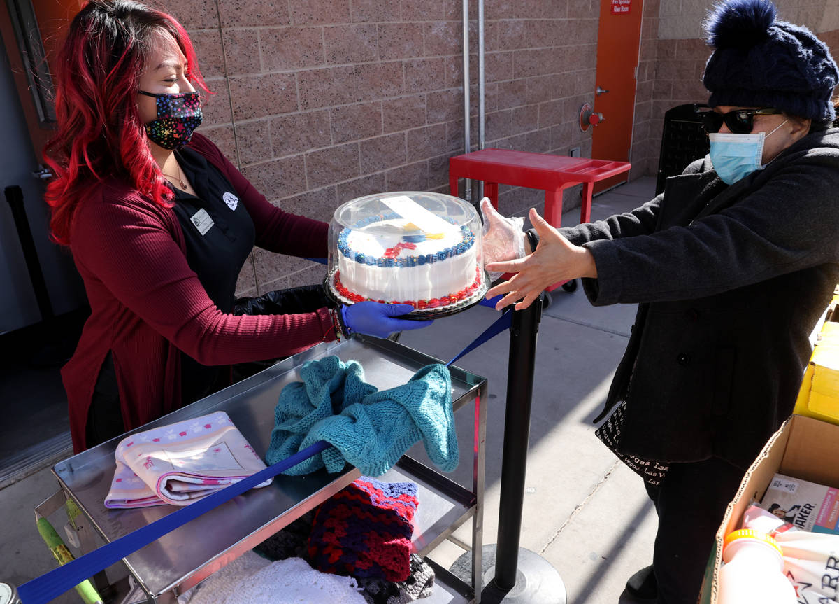 Maria Ochoa offers a cake to an unidentified client at the Hands of Hope Community Food Pantry ...