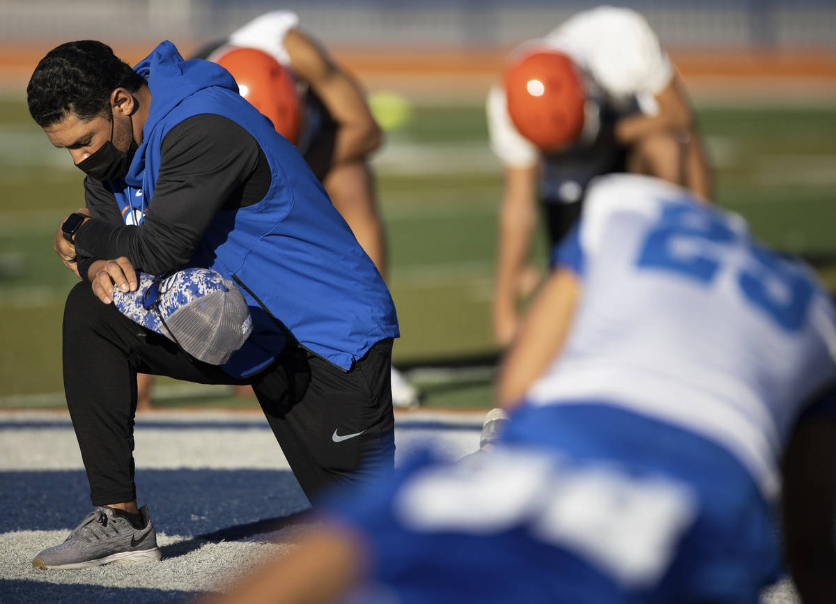 Bishop Gorman head football coach Brent Browner, left, prays with his team after practice on Fr ...