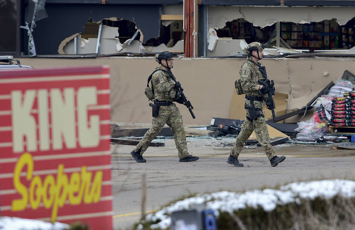 Armed police officers are seen outside broken windows at King Soopers on Table Mesa Drive in Bo ...