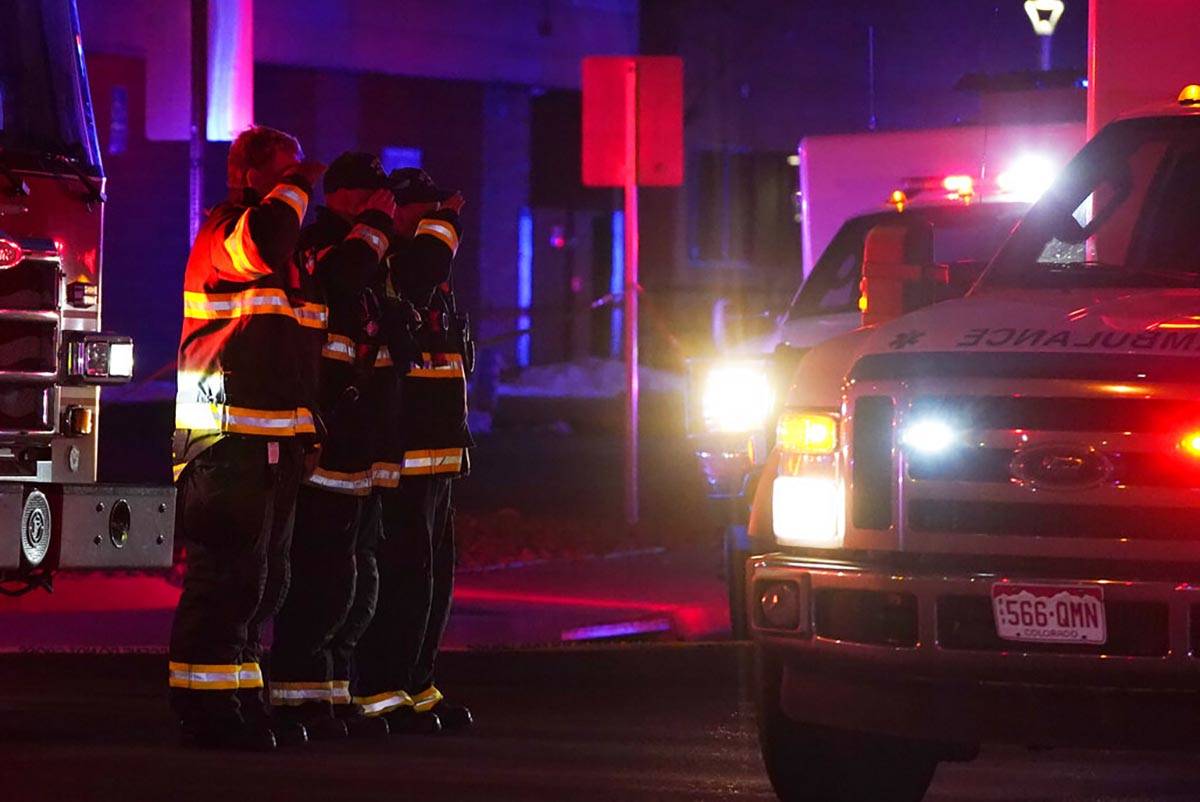 Firefighters salute an ambulance as it leaves a King Soopers grocery store where authorities sa ...