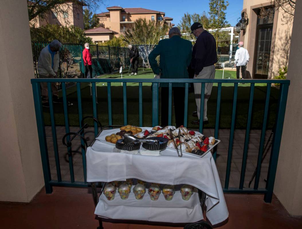 Seniors enjoy the community's newly installed putting green and breakfast treats during a speci ...