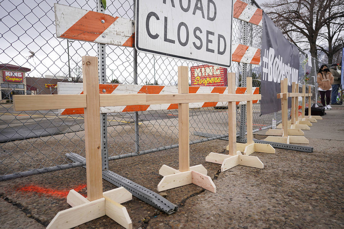 Wooden crosses for the victims stand along a fence put up around the parking lot where a mass s ...