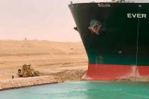In this photo released by the Suez Canal Authority, a cargo ship, named the Ever Green, sits wi ...