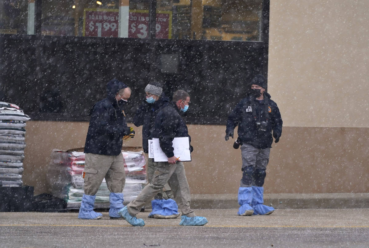 Investigators deal with light snow as they collect evidence in the parking lot where a mass sho ...