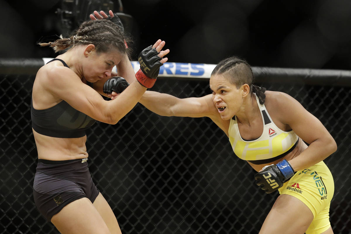 Amanda Nunes, right, hits Miesha Tate during their women's bantamweight championship mixed mart ...