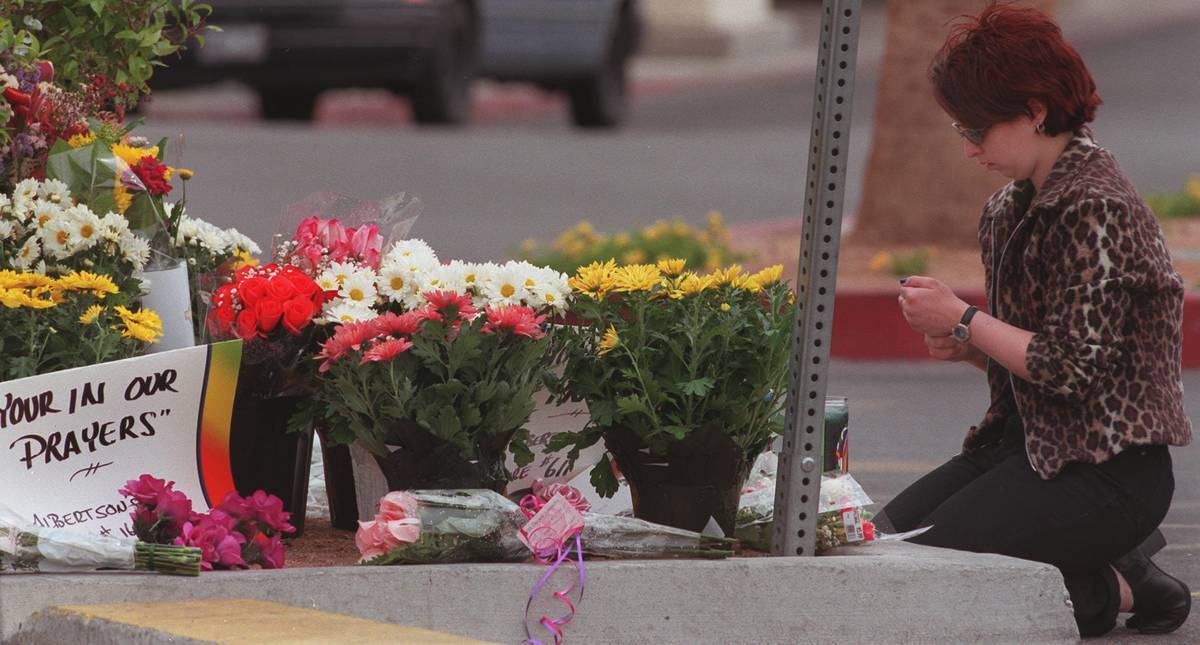 An unidentified Albertson's employee lights a candle Friday June 4,1999 at a makeshift memorial ...