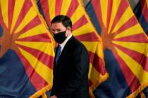 Arizona Republican Gov. Doug Ducey prepares to talk about the latest Arizona COVID-19 informati ...