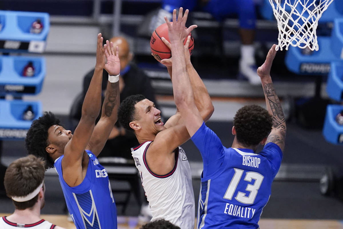 Gonzaga guard Jalen Suggs (1) drives between Creighton guard Shereef Mitchell, left, and Christ ...