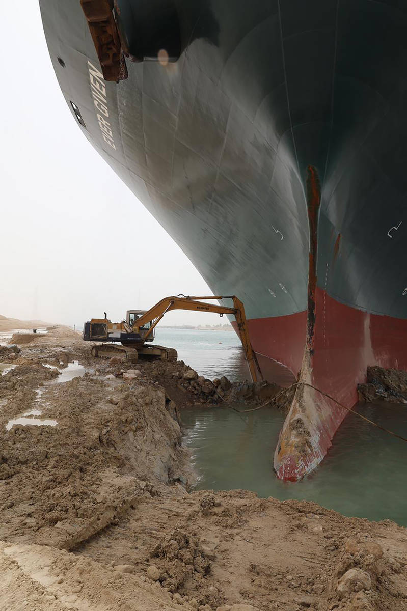 This photo released by the Suez Canal Authority on Thursday, March 25, 2021, shows a backhoe tr ...