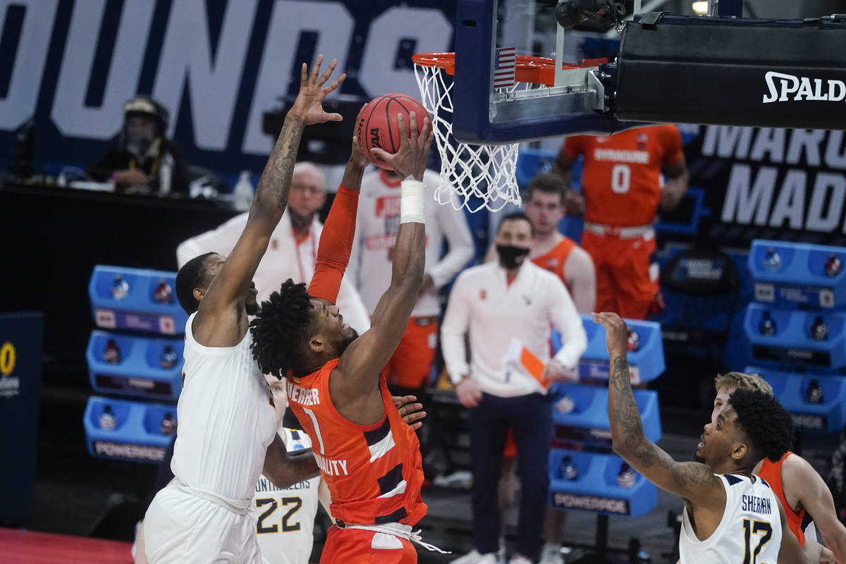 Syracuse's Quincy Guerrier (1) goes up for a dunk against West Virginia's Gabe Osabuohien (3) d ...