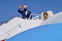 President Joe Biden waves as he boards Air Force One at Andrews Air Force Base, Md., Friday, Ma ...