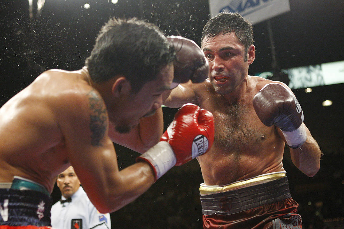 Boxer Manny Pacquiao, left, takes a blow from his opponent Oscar De La Hoya during their welter ...