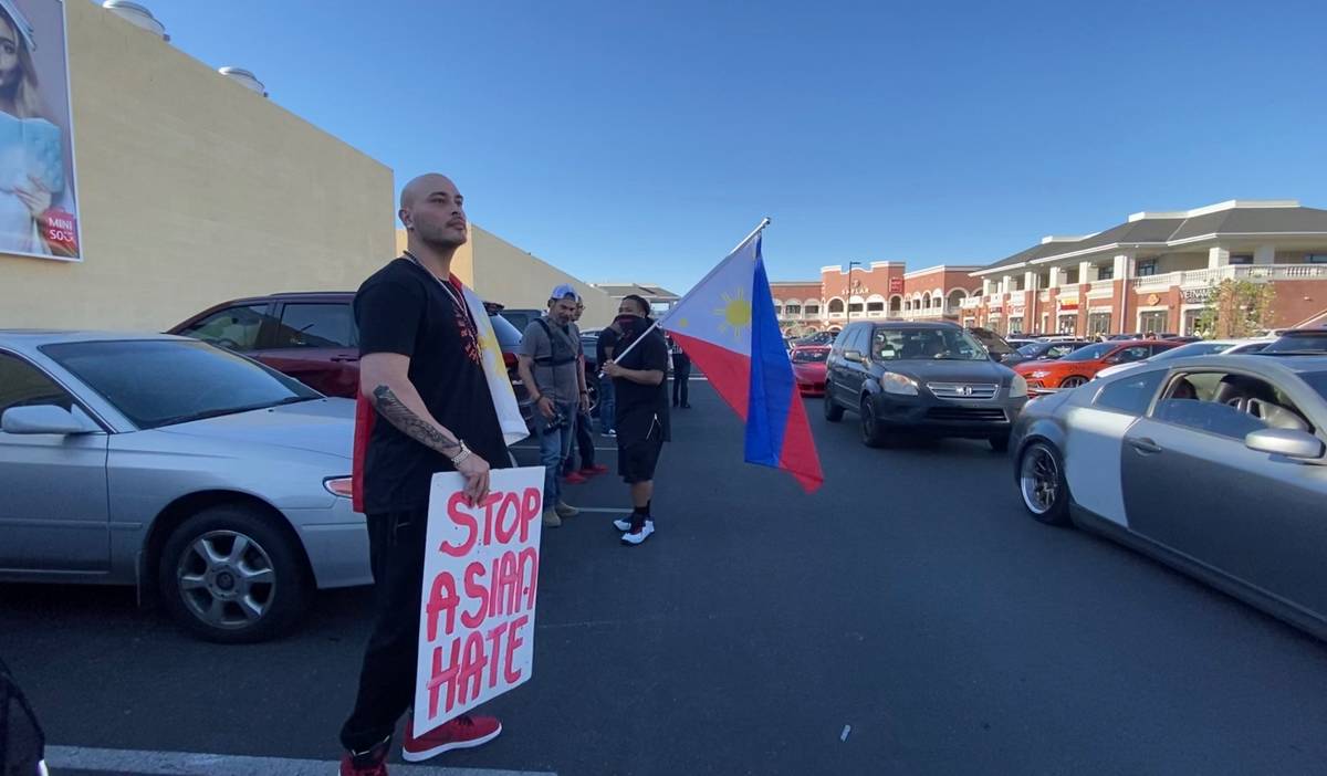 Tony Bentajado, a hip-hop artist who goes by KNine, holds a sign reading "Stop Asian Hate" whil ...