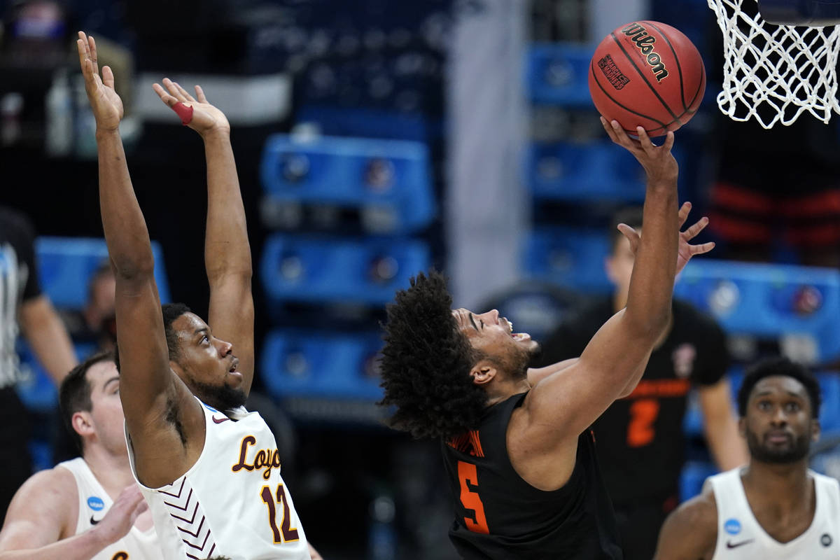 Oregon State guard Ethan Thompson (5) drives to the basket ahead of Loyola Chicago guard Marqui ...
