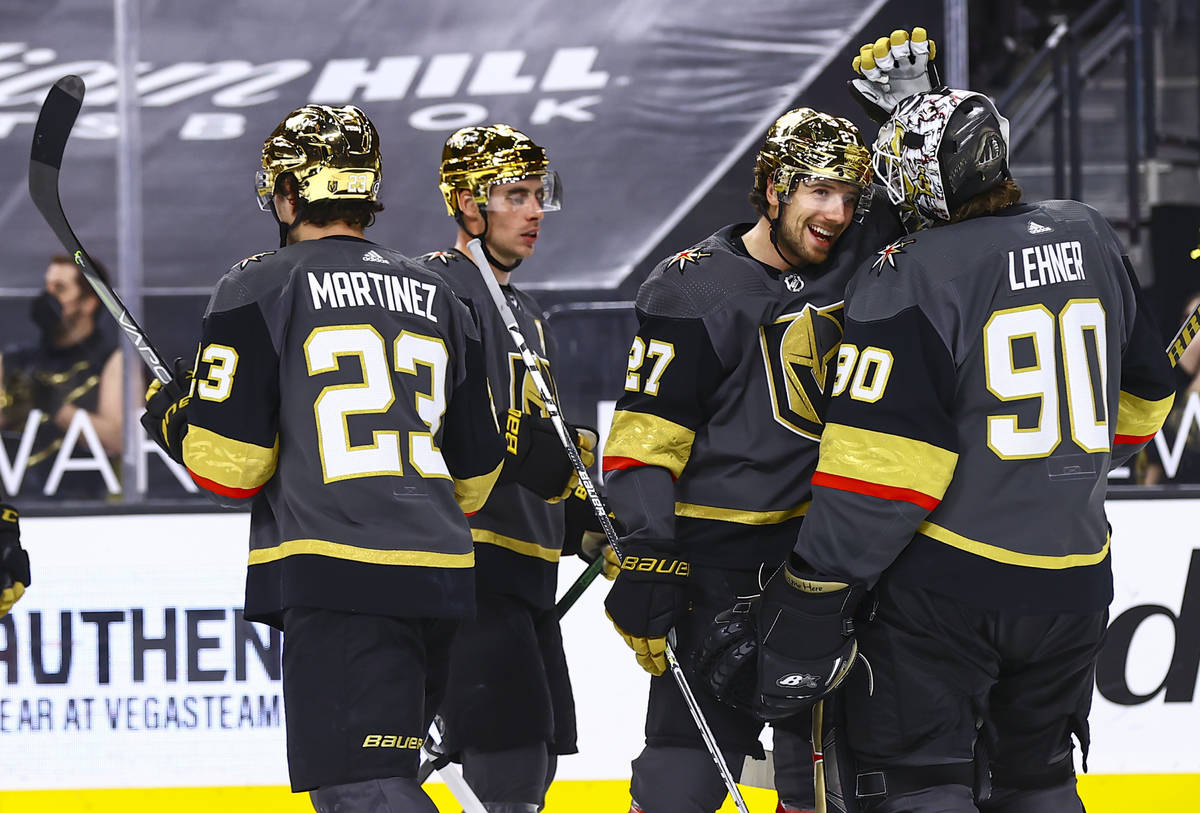 Golden Knights' Shea Theodore (27) celebrates with goaltender Robin Lehner (90) after defeating ...
