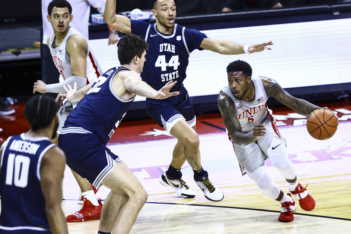 UNLV Rebels guard David Jenkins Jr. (5) drives against Utah State Aggies center Trevin Dorius ( ...