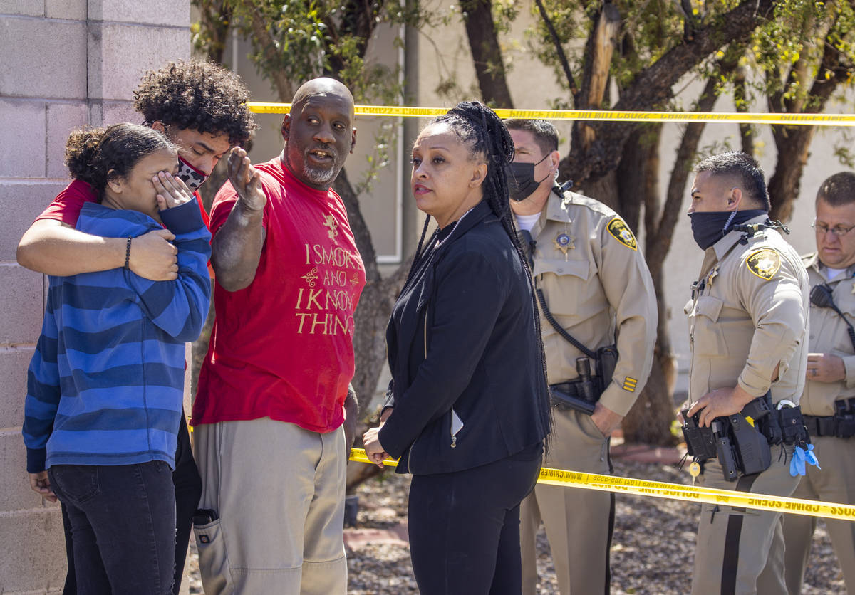 Family members converse with Metro officers near where the Clark County Fire Department works a ...