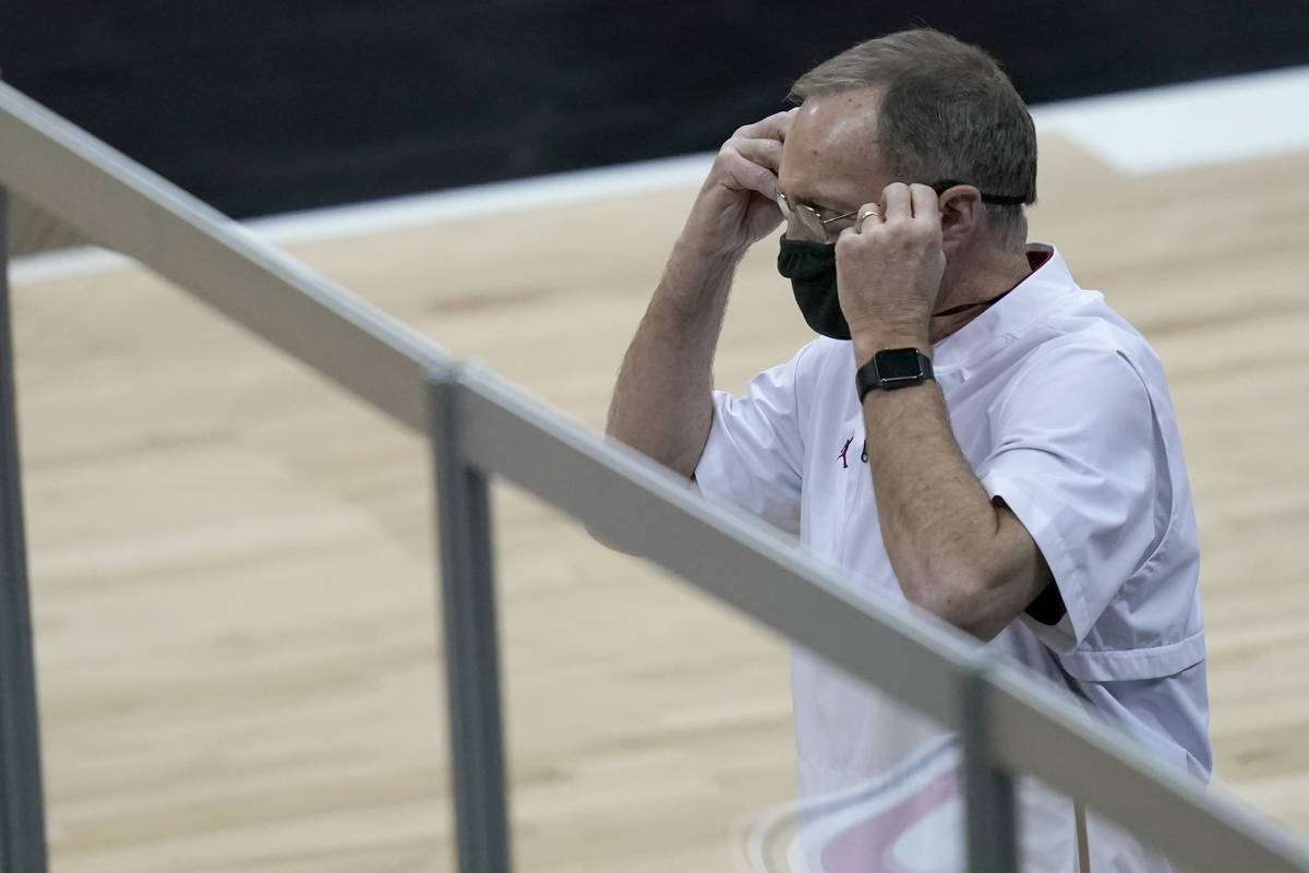 Oklahoma coach Lon Kruger adjusts his mask during the first half of the team's NCAA college bas ...