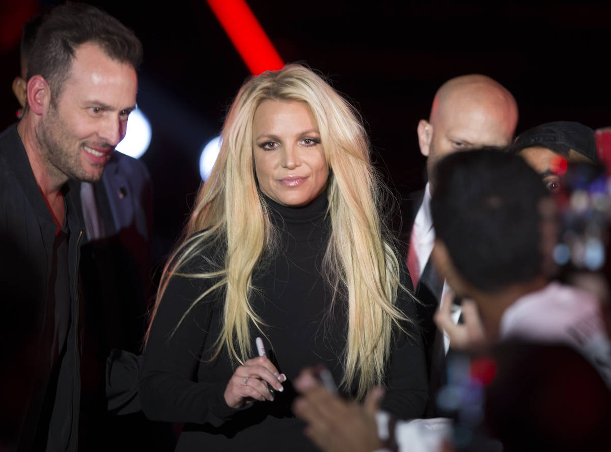 Britney Spears signs an autograph during an event to announce her residency at The Park Theater ...