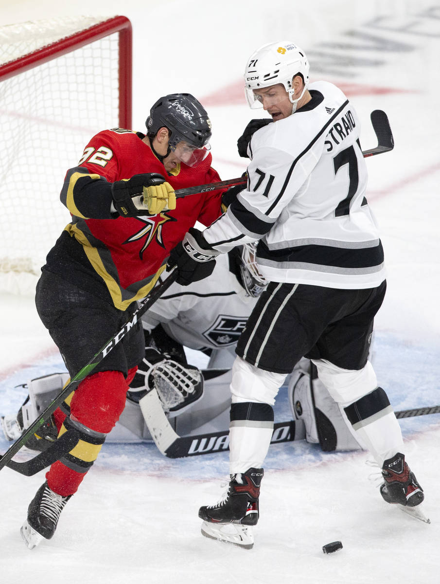Golden Knights left wing Tomas Nosek (92) pushes while Kings defenseman Austin Strand (71) and ...