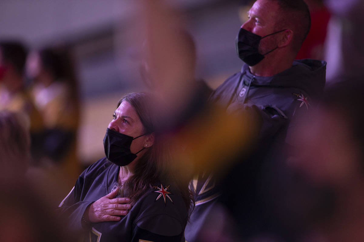 Fans sing the lyrics, "gave proof through the night," of the national anthem during a ...