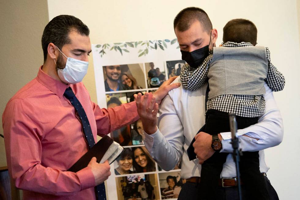 Nick Rose, holding his 2-year-old son, Kaiden, prays before his wife's funeral service. His wif ...