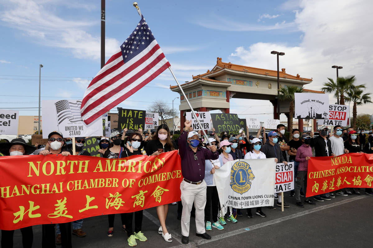 People, including Walter Ho, of Las Vegas, holding flag, rally at a "Stop Asian Hate" ...