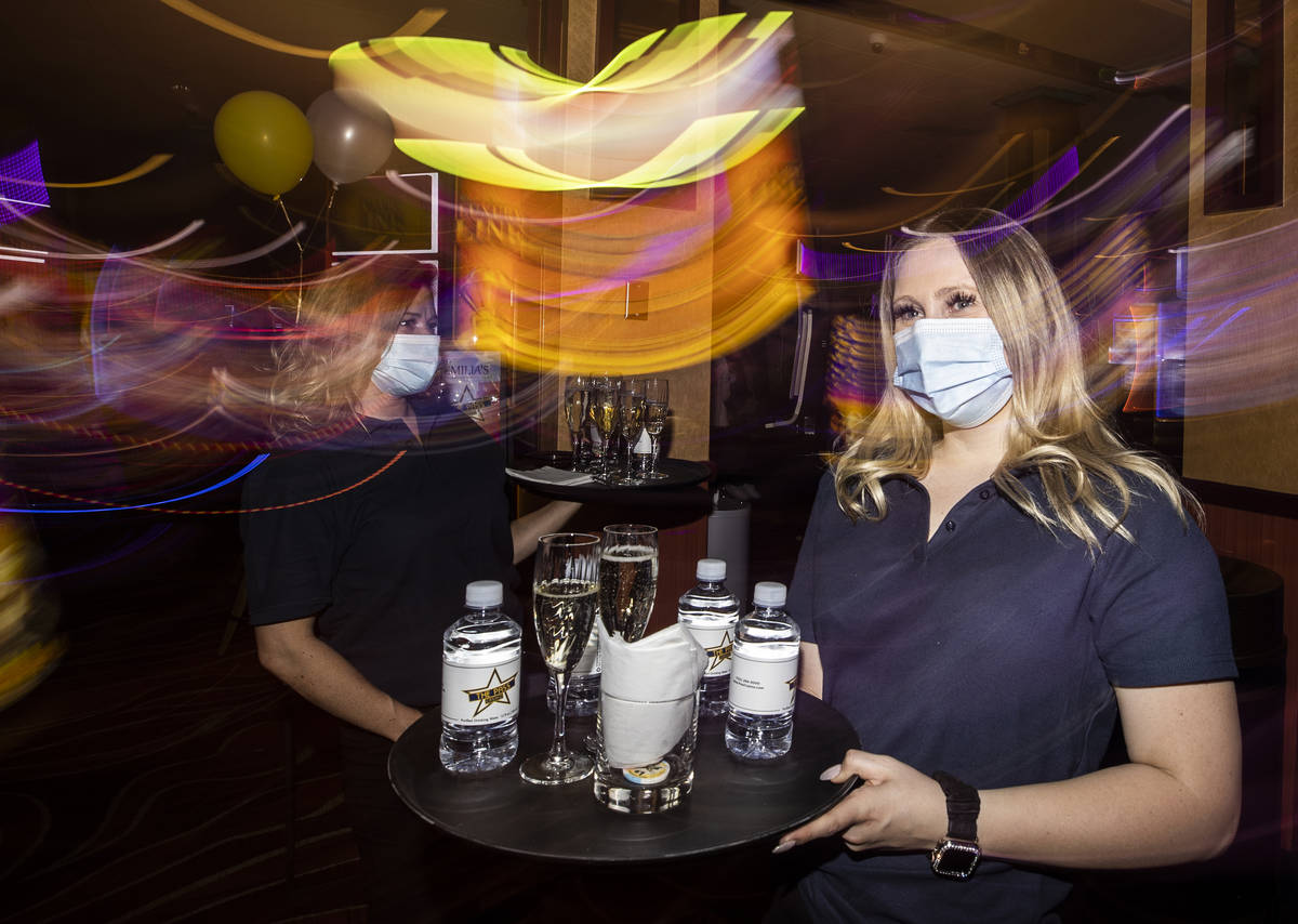Server Audrea Doan delivers drinks to guests during the VIP opening party for The Pass casino o ...