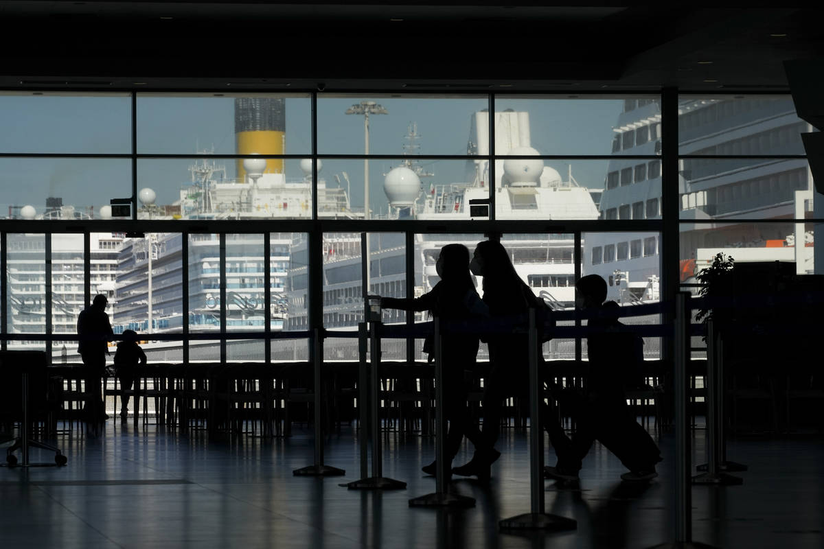 Passengers walk the terminal prior to boarding the MSC Grandiosa cruise ship in Civitavecchia, ...