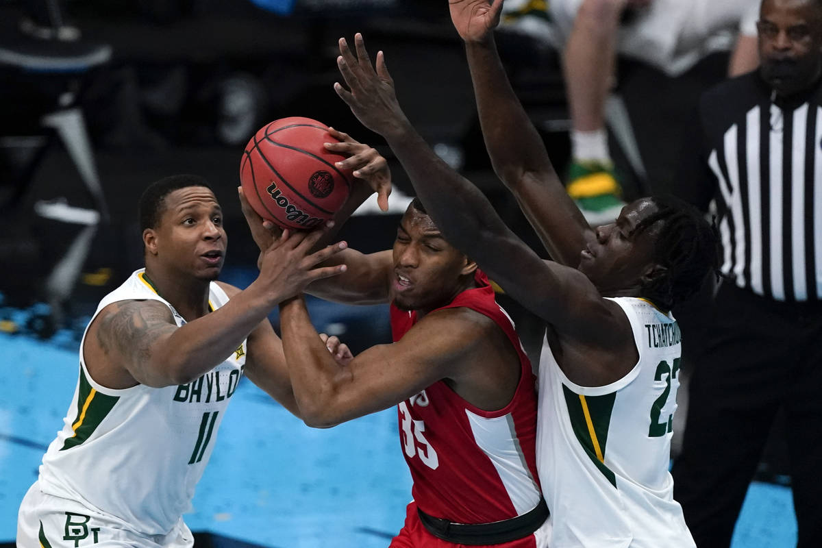 Houston forward Fabian White Jr. (35) passes between Baylor guard Mark Vital (11) and forward J ...