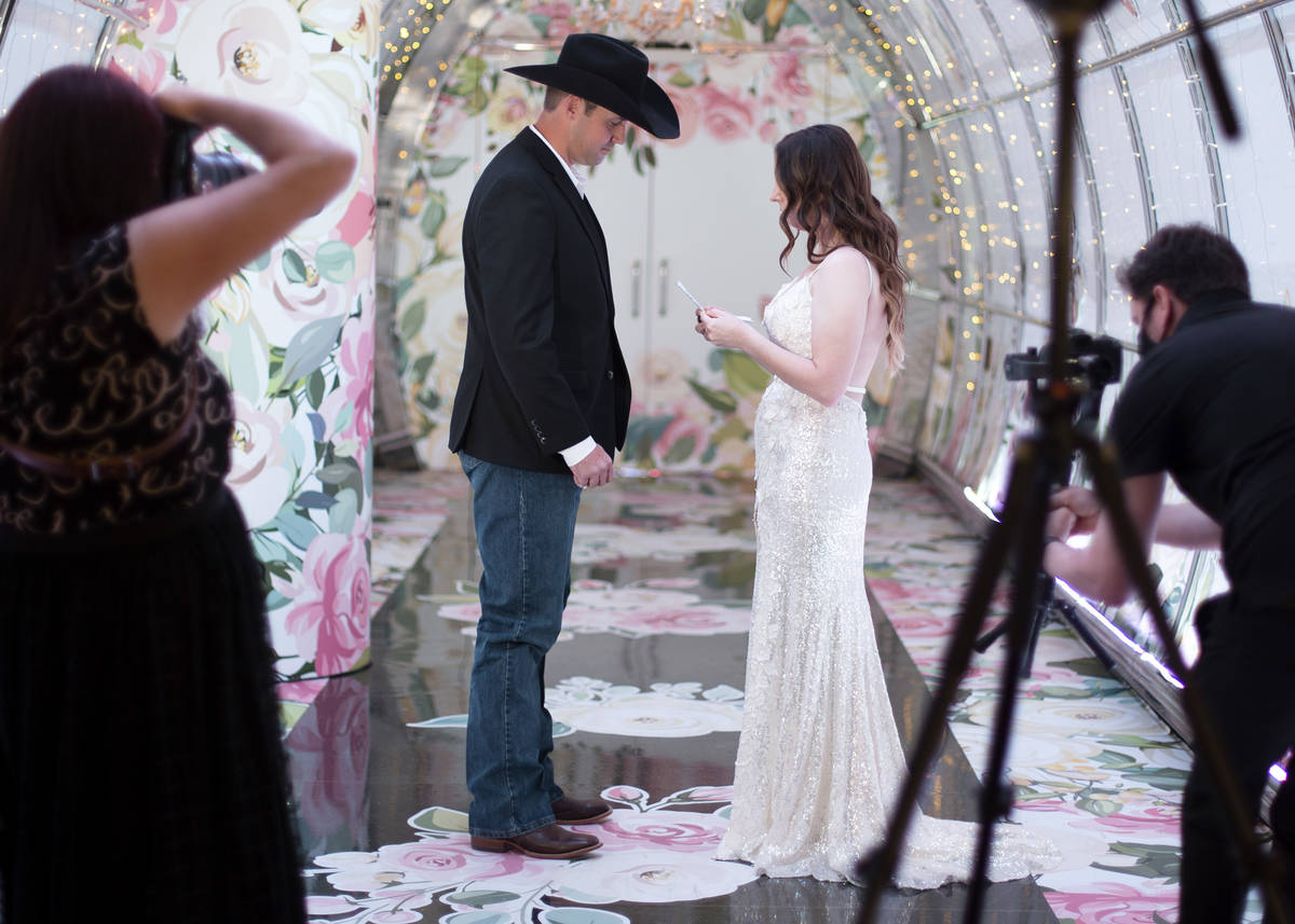 Allen Jones and Kaitlin Pena, of Fort Worth, Texas, exchange vows while photographers capture t ...
