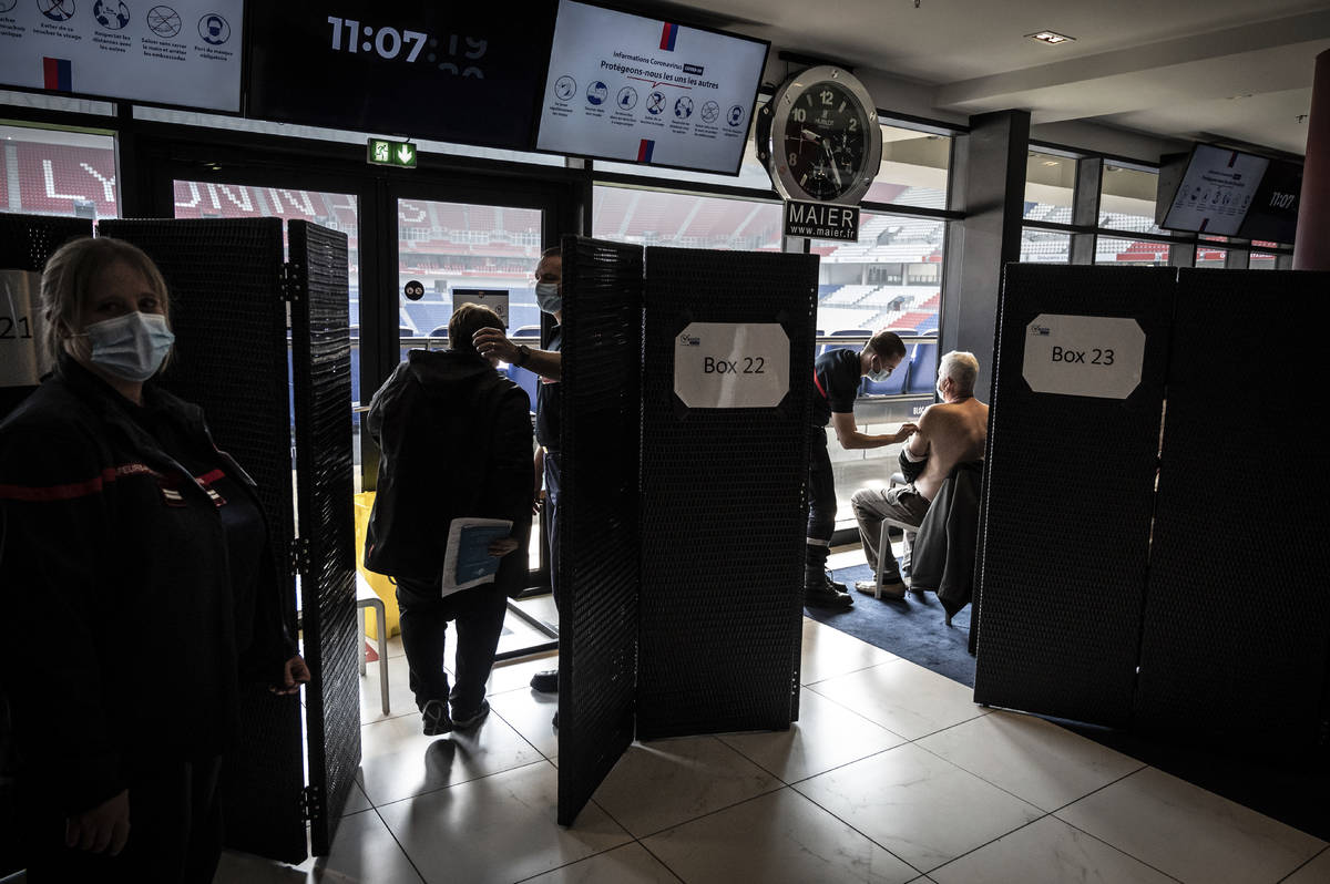 Patients receive an injection of the Moderna Covid-19 vaccine on the opening day of a mass vacc ...