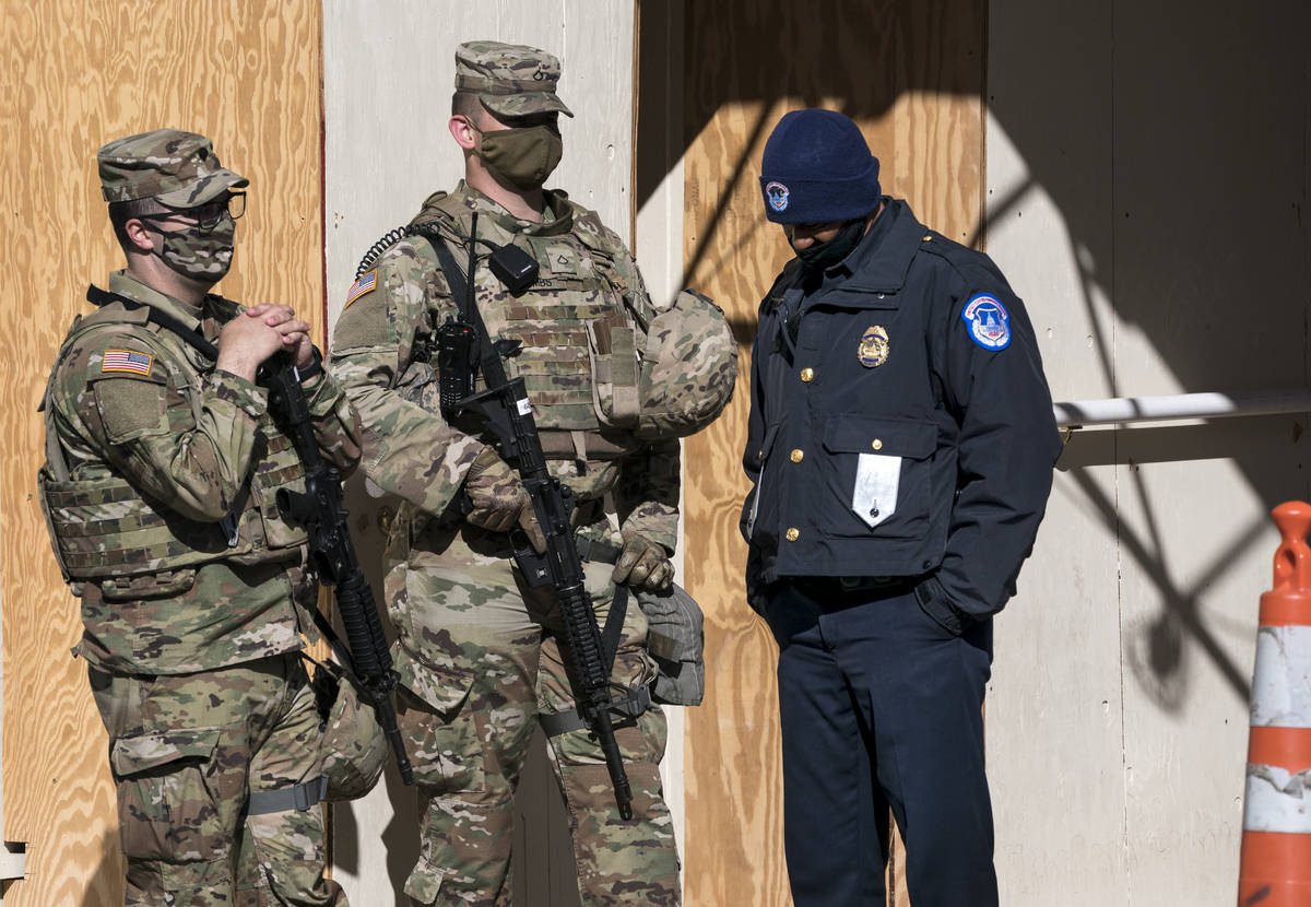 A U.S. Capitol Police officer, right, stands with two National Guard members near the scene whe ...