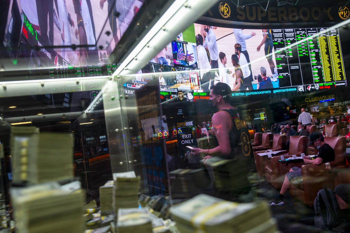 Ralph Mondragon, of Riverside, Calif., right, walks to the Westgate sportsbook windows to colle ...
