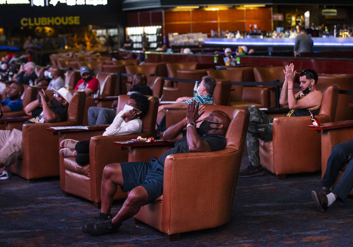 Keith Bowman, of Los Angeles, center, and Ralph Mondragon, right, of Riverside, Calif., cheer a ...