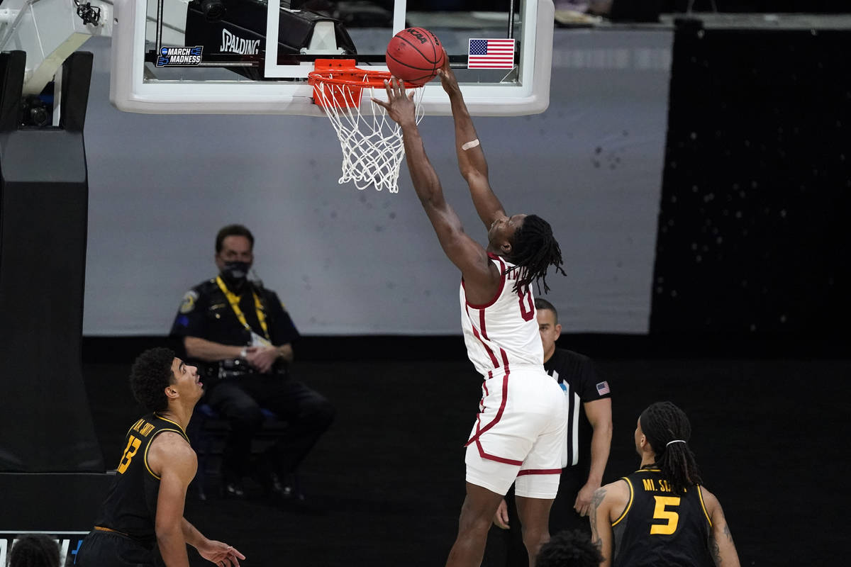 Oklahoma forward Victor Iwuakor dunks the ball over Missouri guard Mark Smith, left, and forwar ...