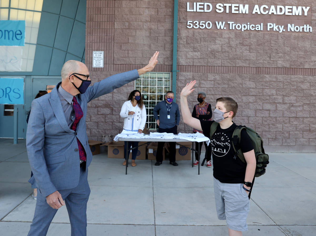 Principal Derek Fialkiewicz gives a virtual high-five to seventh grader Aaiden Bezemer, 12, on ...