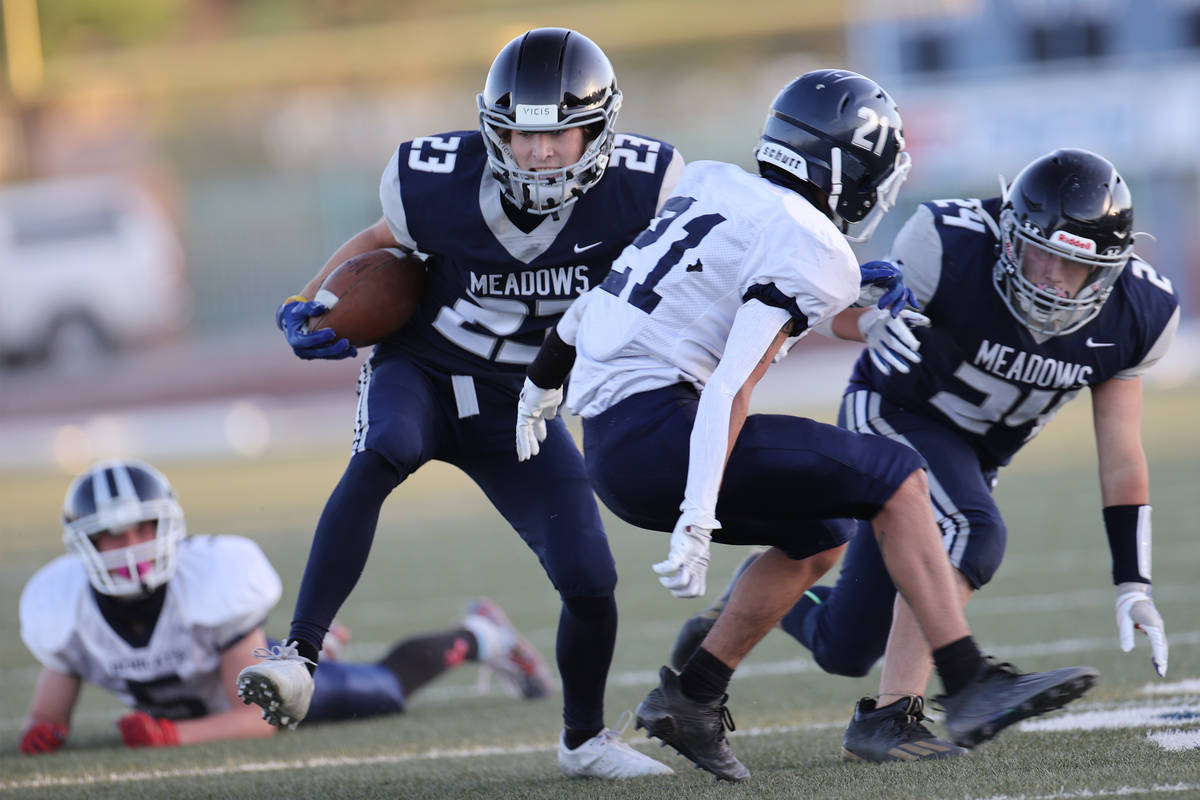 Meadows' Ryan Hannig (23) with his teammate Derek Bain (24), runs the ball under pressure from ...