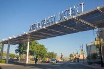 A pedestrian crosses underneath a sign identifying the iconic Water Street District on South Wa ...